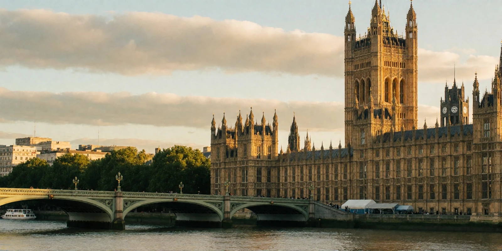 Golden-hour panorama of the Houses of Parliament and the great clock tower along the River Thames in London