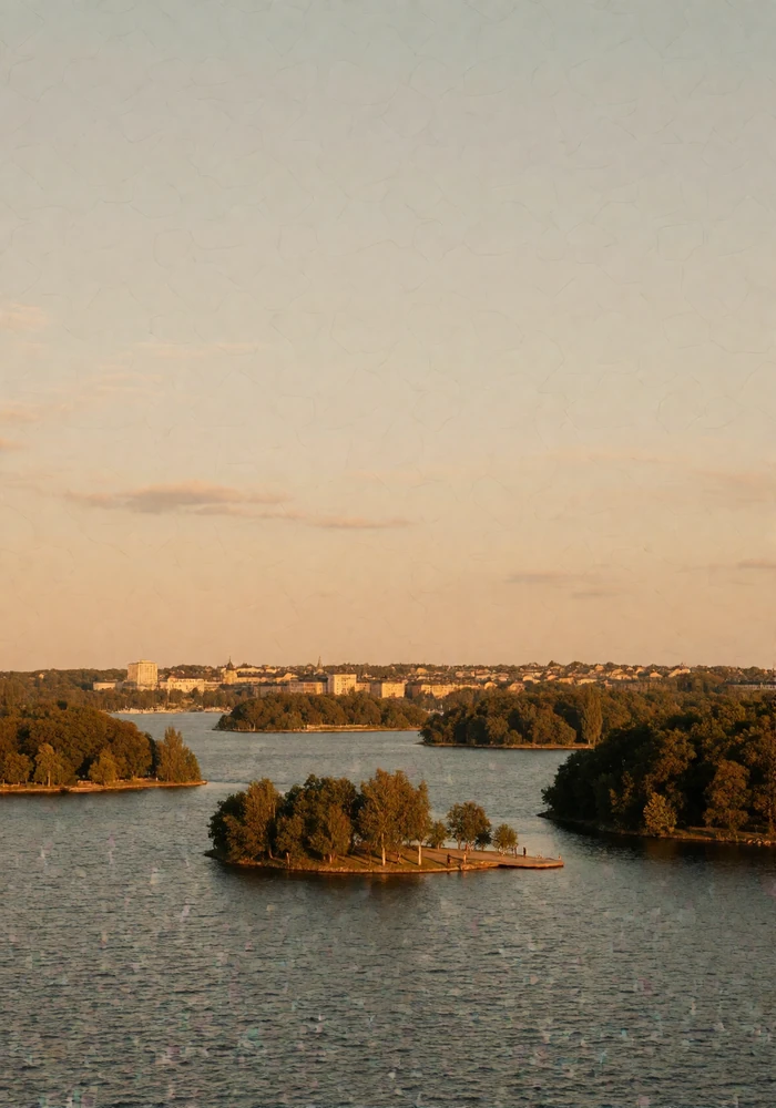 View across Stockholm's water toward low wooded islands and distant pale rooftops